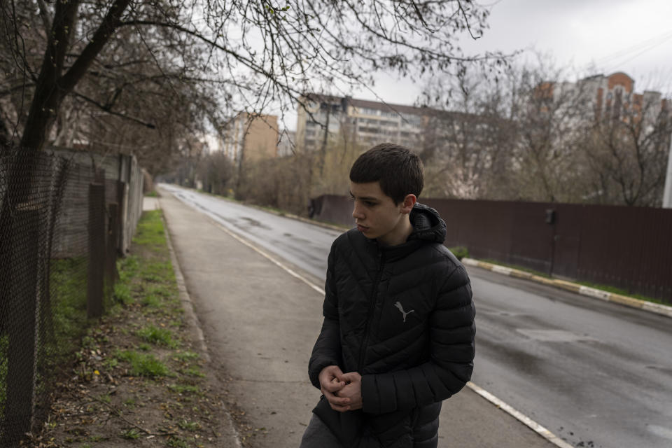 Yura Nechyporenko, de pie en el lugar donde fue ejecutado su padre en Bucha, a las afueras de Kiev, Ucrania, el jueves 21 de abril de 2022. El joven sobrevivió a un intento de ejecución de soldados rusos, mientras que su padre murió, y ahora la familia pide justicia. (AP Foto/Petros Giannakouris)