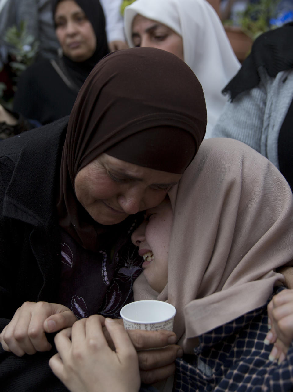 FILE - In this March 21, 2019 file photo, relatives of Palestinian Ahmad Manasra mourn during his funeral in the West Bank village of Wad Fokin, near Bethlehem. In August 2020, Israeli military prosecutors offered three months of community service to a soldier who shot and killed Manasra, an unarmed Palestinian man who exited his vehicle to assist a second motorist who had also been shot -- in a case that has drawn renewed attention to a justice system that Palestinians and human rights activists say has created an atmosphere of impunity. The deal is now being reviewed by the Israeli Supreme Court. (AP Photo/Nasser Nasser, File)