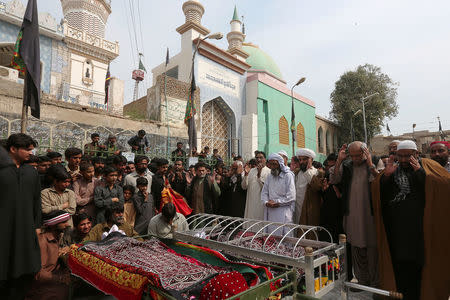 FILE PHOTO - Men and relatives gather to attend funeral prayers for victims killed in a suicide blast at the tomb of Sufi saint Syed Usman Marwandi, also known as the Lal Shahbaz Qalandar shrine, during a funeral in Sehwan Sharif, Pakistan's southern Sindh province, February 17, 2017. REUTERS/Akhtar Soomro/File Photo