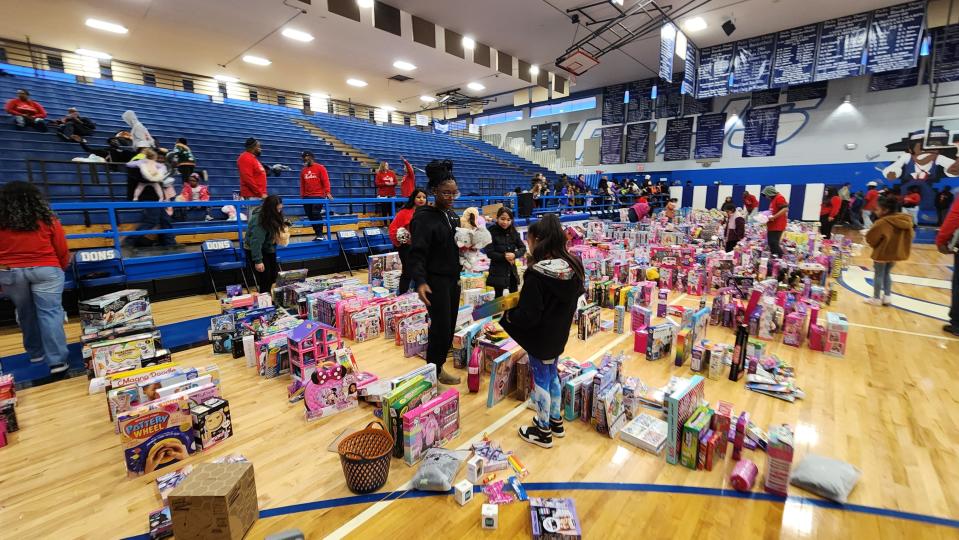 A volunteer helps a child choose a toy Saturday at the 10th annual Northside Toy Drive held at the Palo Duro High School Gym in Amarillo.