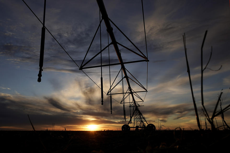 A center pivot irrigation sprinkler is silhouetted against the sky at sunset Thursday, Jan. 5, 2023, near Deerfield, Kan. Lawmakers are looking to take up groundwater issues in western Kansas in the upcoming session as the Kansas Water Authority is urging stricter usage measures to try to slow the steady decline of water levels in the Ogallala Aquifer. (AP Photo/Charlie Riedel)