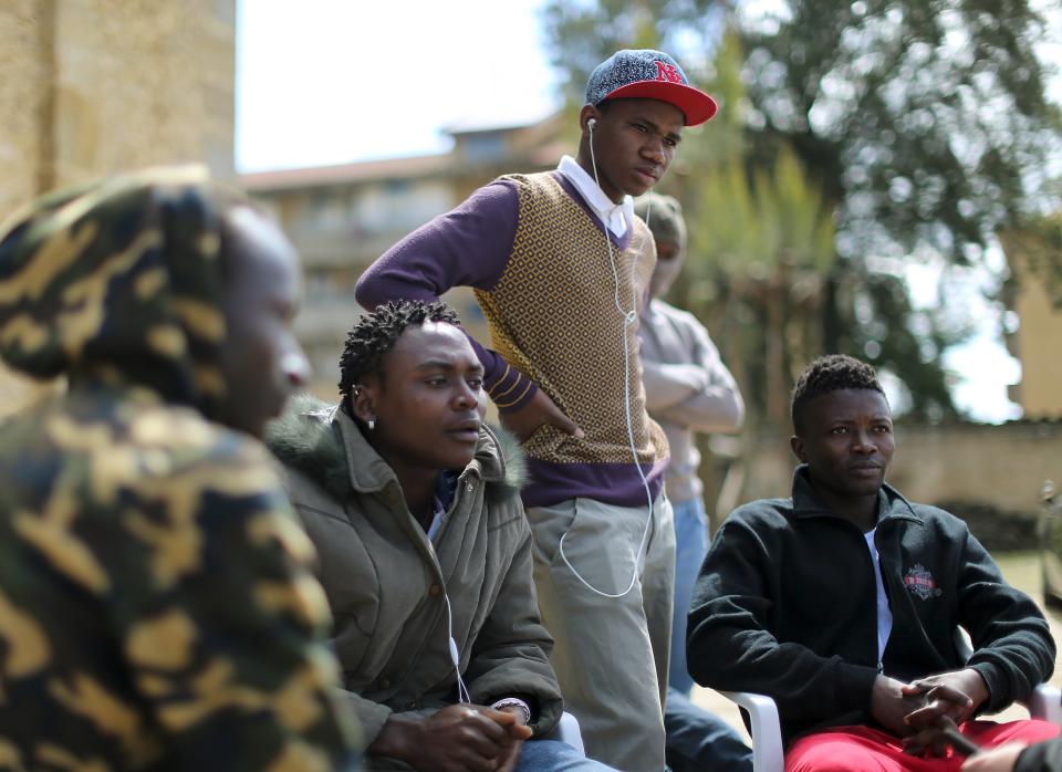 Adolescent migrants Mustafa (2nd R) from Gambia and Ishmael (R) from Sierra Leone stand in a courtyard at an immigration centre in Caltagirone, Sicily March 18, 2015. The number of migrants reaching Italy by sea this year is set to top last year's record of 170,000, the International Organization for Migration (IOM) said. In the past week alone 10,000 have arrived. Another 400 people drowned before making it to Italy's shores, survivors said. The number of minors traveling alone in this mass migration has soared -- underage arrivals to Italy tripled in 2014 from the previous year. Picture taken March 18, 2015. To match Insight ITALY-MIGRANTS/BOYS REUTERS/Alessandro Bianchi