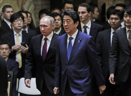 Russian President Vladimir Putin walks with Japanese Prime Minister Shinzo Abe during a joint news conference in Tokyo, Japan, December 16, 2016. REUTERS/Alexander Zemlianichenko/Pool