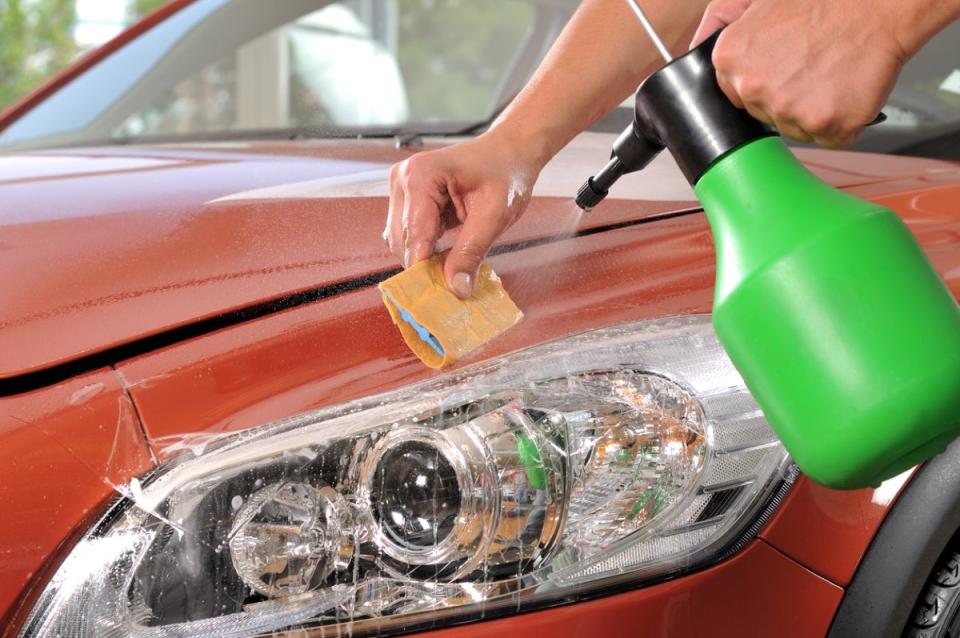 Person spraying headlight