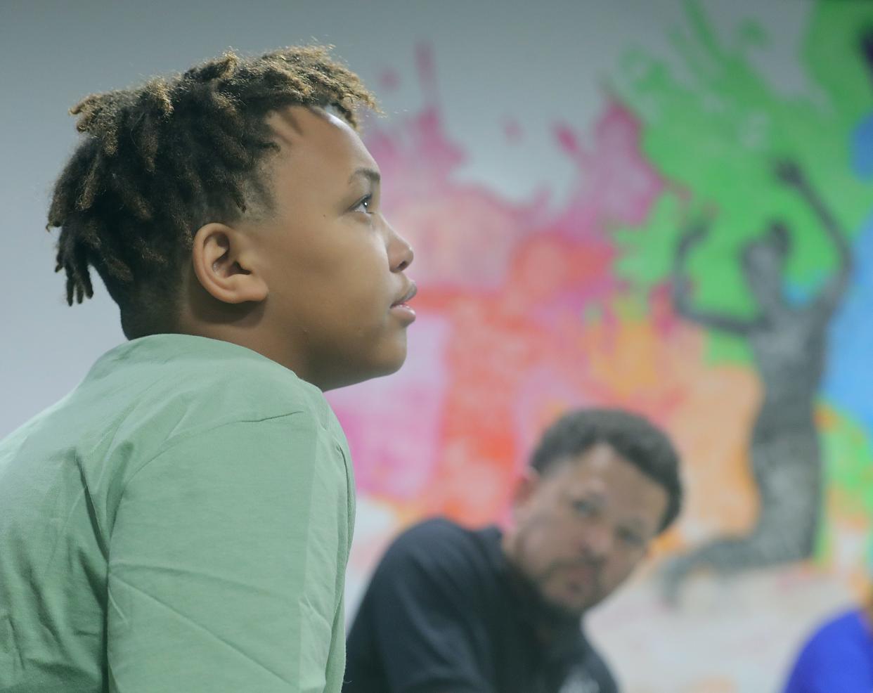 Saint-Michael Walker talks about his experience with gun violence as Brandon R. Scarborough, executive director of Dreams Academy, listens during a meeting at The House of the Lord on June 26 in Akron.