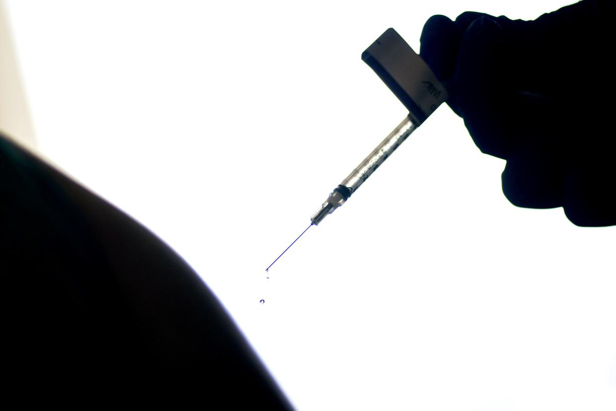 A droplet falls from a syringe after a health care worker was injected with the Pfizer COVID-19 vaccine at a hospital in Providence, R.I.  