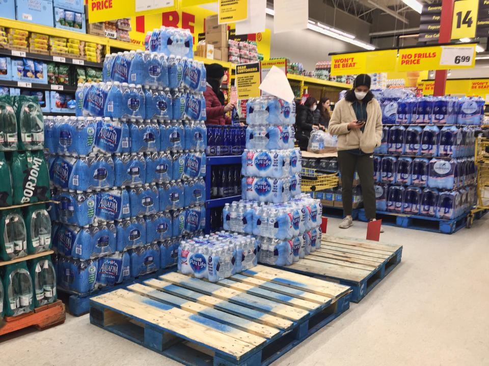 People scramble to purchace bottled water at a grocery store as panic buying and hoarding of food and sanitary items continues due to fear of the novel coronavirus (COVID-19) across the country on March 17, 2020 in Toronto, Ontario, Canada. Canadians emptied shelves of grocery stores and markets to stockpile supplies such as toilet paper and canned goods. In many stores have begun rationing items and limiting the amount of people allowed to enter the store. The World Health Organization has declared COVID-19 a global pandemic. (Photo by Creative Touch Imaging Ltd./NurPhoto via Getty Images)