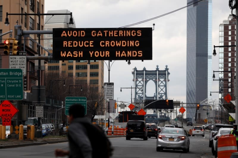 Signage regarding the coronavirus disease (COVID-19) is displayed at the entrance to the Manhattan Bridge in the Brooklyn borough of New York City