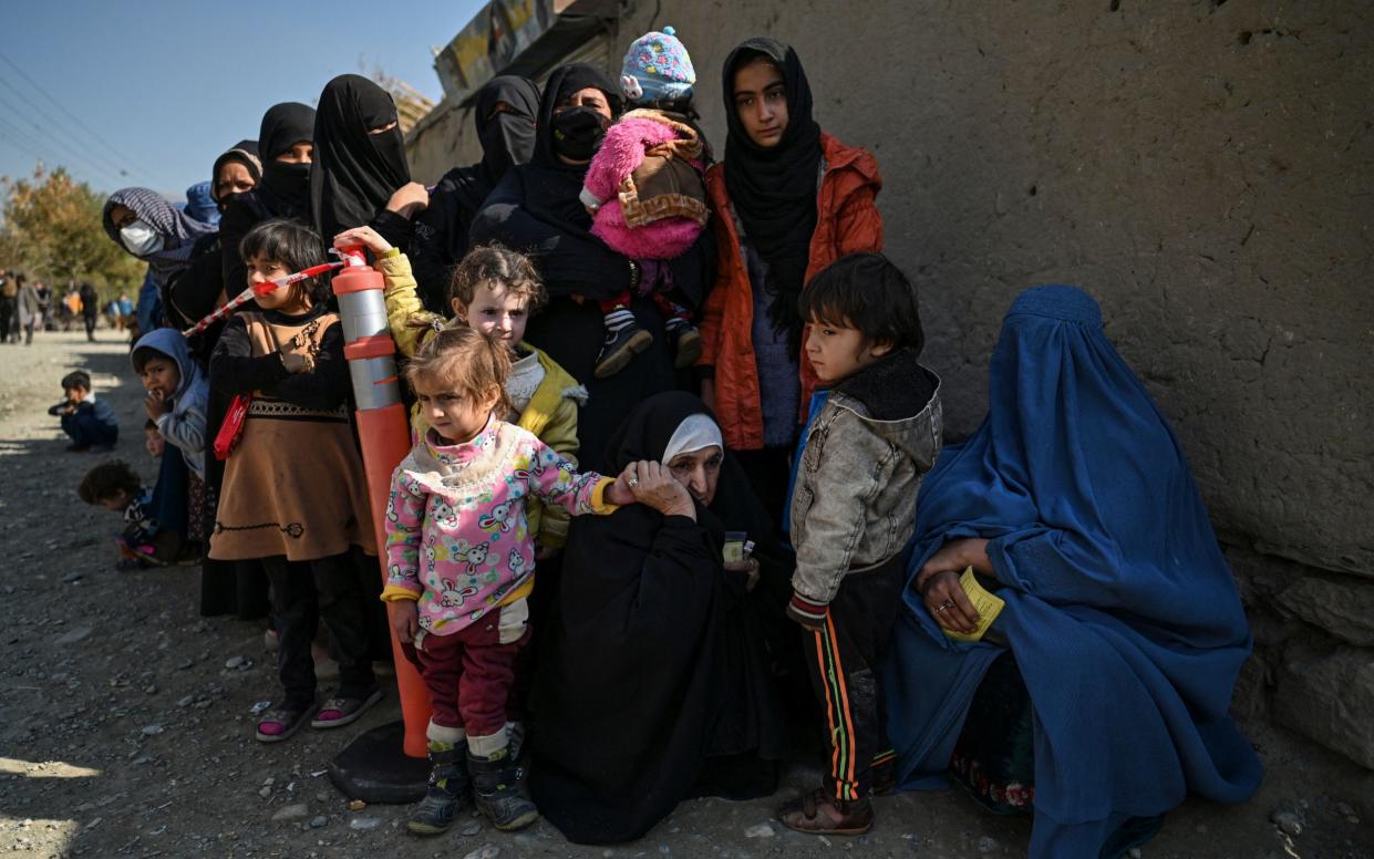 Women and children queue for food aid in Afghanistan - Hector Retamal/AFP
