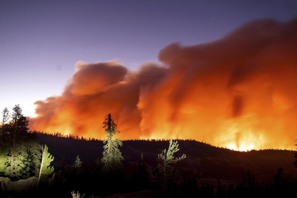 FILE - In this Aug. 29, 2021, file photo, taken with a long camera exposure, the Caldor Fire burns in Eldorado National Forest, Calif. The 2-month-old California wildfire that threatened the Lake Tahoe resort region during the summer has been declared 100% contained. The fire reached the containment milestone late Wednesday, Oct. 20, 2021. (AP Photo/Noah Berger, File)