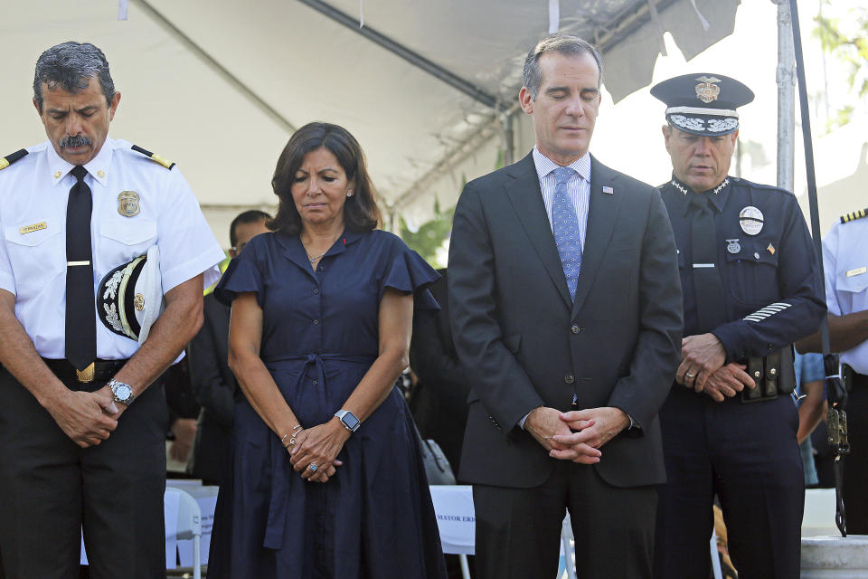 Los Angeles Mayor Eric Garcetti, second from right, and Paris Mayor Anne Hidalgo join Police Chief Michel Moore, right, and Fire Chief Ralph Terrazas during a ceremony marking the 17th anniversary of the Sept. 11, 2001 terrorist attacks on America, at the Los Angeles Fire Department's training center Tuesday, Sept. 11, 2018. Americans looked back on 9/11 Tuesday with tears and somber tributes. Victims' relatives said prayers for their country, pleaded for national unity and pressed officials not to use the 2001 terror attacks as a political tool in a polarized nation. (AP Photo/Reed Saxon)