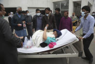 A patient is transferred after angry lawyers attack on a hospital in Lahore, Pakistan, Wednesday, Dec. 11, 2019. Hundreds of Pakistani lawyers, angered over alleged misbehavior of some doctors toward one of their colleagues last month, stormed a cardiology hospital in the eastern city of Lahore, setting off scuffles with the facility's staff and guards that left heart patients unattended for several hours. (AP Photo/K.M. Chaudary)