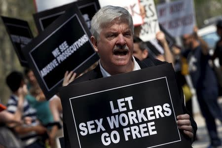 Demonstrators hold signs as they protest the arrests of male escort service Rentboy.com staffers outside United States Court in the Brooklyn borough of New York City, September 3, 2015. REUTERS/Mike Segar