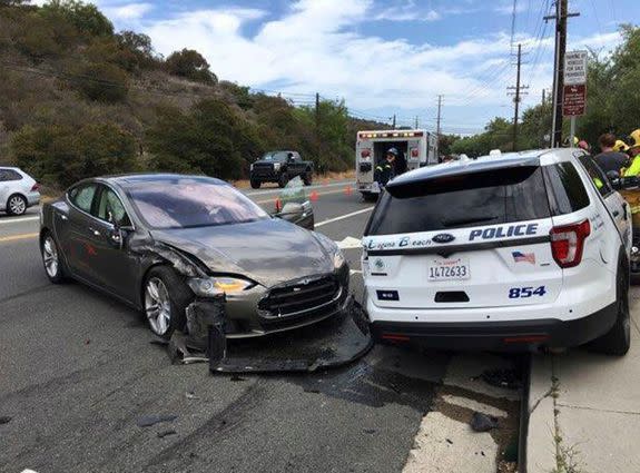 A Tesla sedan, left, in Autopilot mode that crashed into a parked police cruiser in Laguna Beach, California.