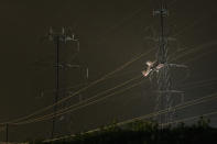 A small plane rests on live power lines after crashing, Sunday, Nov. 27, 2022, in Montgomery Village, a northern suburb of Gaithersburg, Md. (AP Photo/Tom Brenner)
