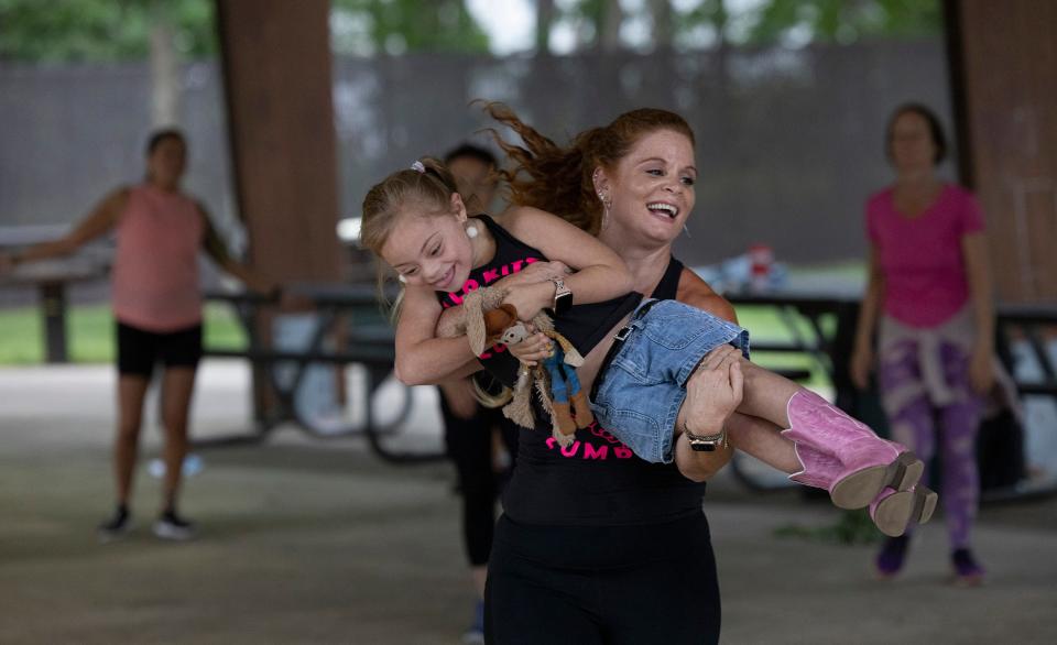 Dawn Kramer lifts her daughter Hazel while teaching a free Zumba class at Gille Park in Lacey. On Saturday, Kramer will be given a proclamation by the township.