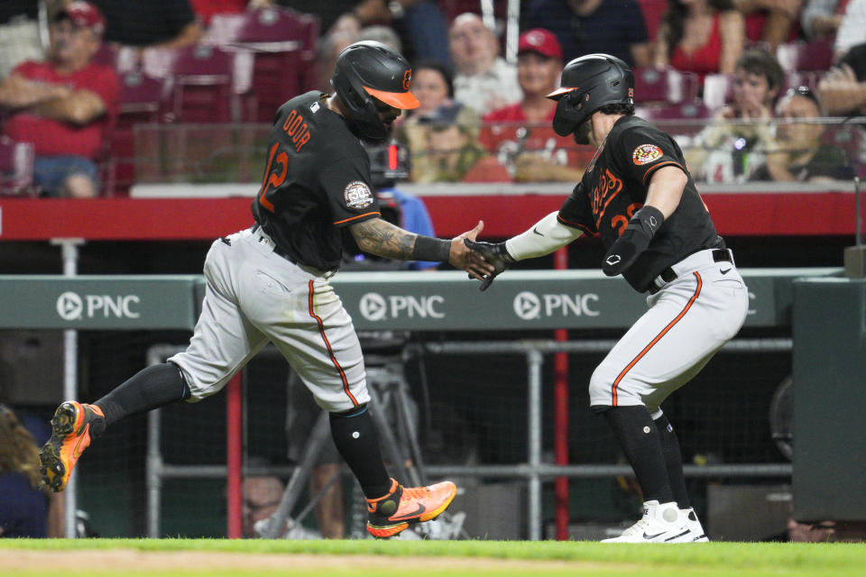 Baltimore Orioles' Rougned Odor (12) celebrates with Ryan McKenna (26) after they scored against the Cincinnati Reds during the ninth inning of a baseball game Friday, July 29, 2022, in Cincinnati. (AP Photo/Jeff Dean)