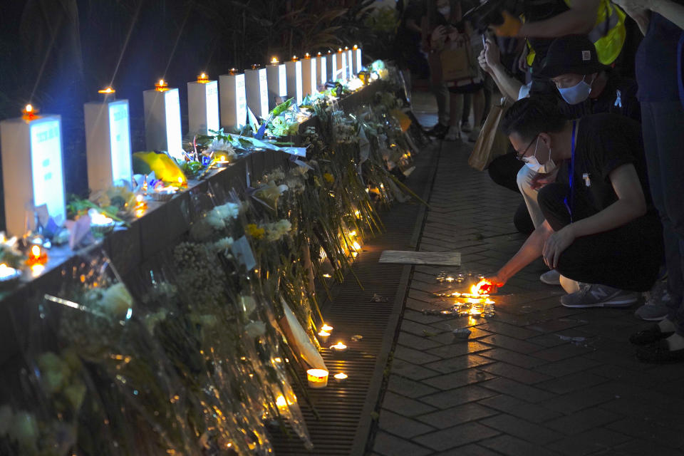 Mourners light candles as they pay respect at the site to mark one year memorial where a man fell to his death after hanging a protest banner against the extradition bill on the scaffolding of a shopping mall in Admiralty, Hong Kong, Monday, June 15, 2020. Protesters in Hong Kong got the government to withdraw extradition legislation last year, but now they're getting a more dreaded national security law, and the message from Beijing is that protest is futile. (AP Photo/Vincent Yu)