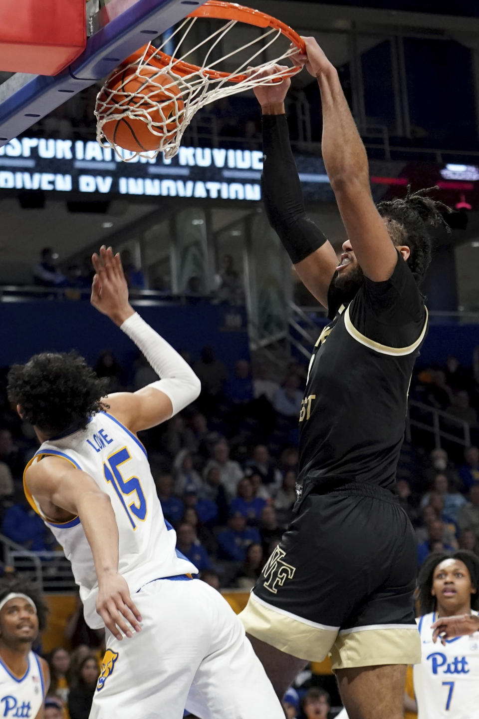 Wake Forest forward Efton Reid III, right, dunks over Pittsburgh guard Jaland Lowe (15) during the first half of an NCAA college basketball game Wednesday, Jan. 31, 2024, in Pittsburgh. (AP Photo/Matt Freed)