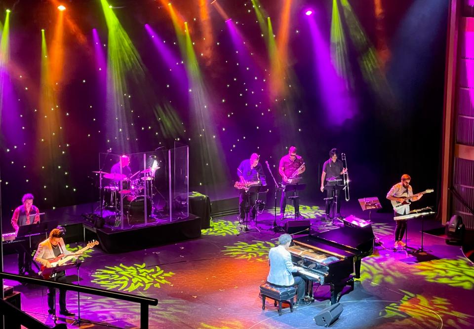 stage on cruise ship lit up with purple, orange, and green lights