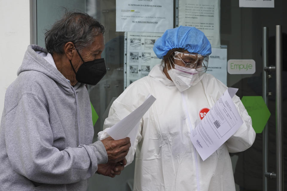 Man gets his results after getting tested for COVID-19, at a pharmacy in Mexico City, Monday, Jan. 10, 2022. (AP Photo/Marco Ugarte)