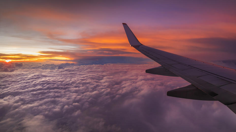 An airplane's wings amongst the sunset and clouds