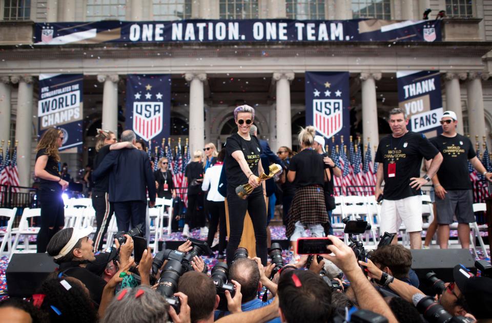 TOPSHOT - USA women's soccer player Megan Rapinoe holds the trophy in front of the City Hall after  a ticker tape parade for the women's World Cup champions on July 10, 2019 in New York. - Amid chants of "equal pay," "USA" and streams of confetti, the World Cup-winning US women's soccer team was feted by tens of thousands of adoring fans with a ticker-tape parade in New York on Wednesday. (Photo by Johannes EISELE / AFP)        (Photo credit should read JOHANNES EISELE/AFP/Getty Images)