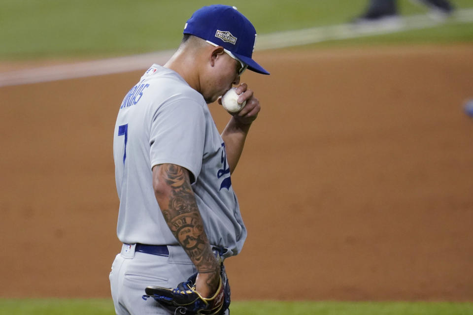 Los Angeles Dodgers' Julio Urias kisses the baseball as he prepares to face the San Diego Padres during the second inning in Game 3 of a baseball National League Division Series Thursday, Oct. 8, 2020, in Arlington, Texas. (AP Photo/Sue Ogrocki)