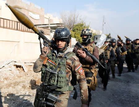 Iraqi Special Operations Forces (ISOF) carry weapons during clashes with Islamic State militants in frontline near university of Mosul, Iraq, January 13, 2017. REUTERS/Ahmed Saad/Files