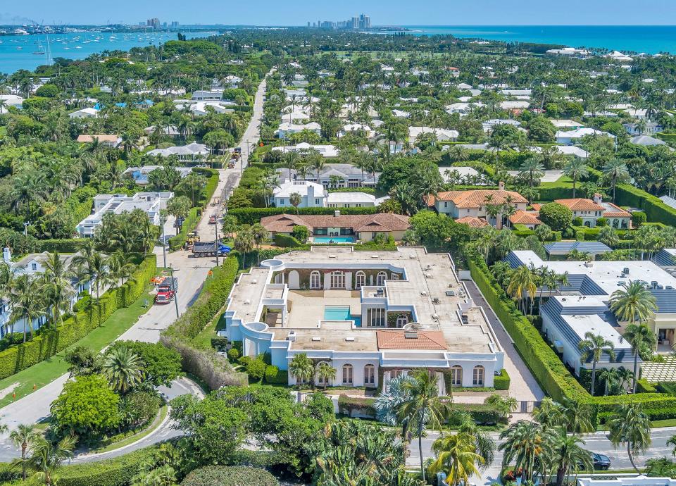 A 1996 courtyard-layout house at 7 La Costa Way in Palm Beach, foreground, has been listed with remodeling plans for $39.9 million after selling in 2022 for $31.8 million.