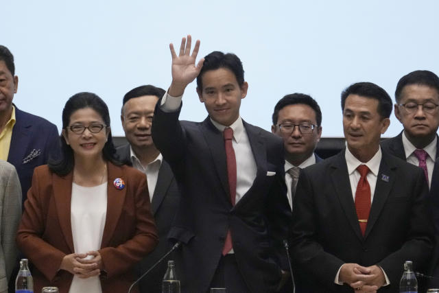 Leader of Move Forward Party Pita Limjaroenrat, center, waves during a press conference with other party leaders, in Bangkok, Thailand, Thursday, May 18, 2023. Thailand's election winner Move Forward Party on Thursday announced an 8-party coalition that its leader declared will become a "democratic government of the people. (AP Photo/Sakchai Lalit)