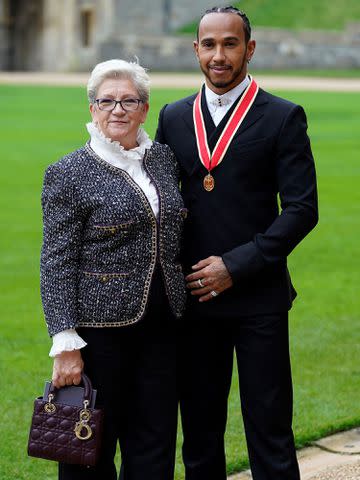 <p>ANDREW MATTHEWS/POOL/AFP/Getty</p> Lewis Hamilton stands with his mother Carmen Larbalestier after being appointed as a Knight Bachelor (Knighthood) for services to motorsports at Windsor Castle in Windsor, west of London on December 15, 2021.