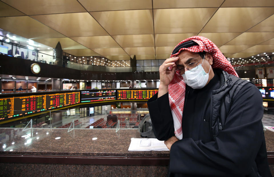 A Kuwaiti trader wearing a protective mask follows the market at the Boursa Kuwait stock exchange in Kuwait City on March 1, 2020. - Boursa Kuwait decided to close the main trading hall due to the COVID-19 coronavirus disease developments. Stock markets in the oil-rich Gulf states plunged on March 1 over fears of the impact of the coronavirus, which also battered global bourses last week. All of the seven exchanges in the Gulf Cooperation Council (GCC), which were closed the previous two days for the Muslim weekend, were hit as oil prices dropped below $50 a barrel. The region's slide was led by Kuwait Boursa, where the All-Share Index fell 10 percent, triggering its closure. Kuwait's bourse was closed for most of last week for national holidays. (Photo by YASSER AL-ZAYYAT / AFP) (Photo by YASSER AL-ZAYYAT/AFP via Getty Images)