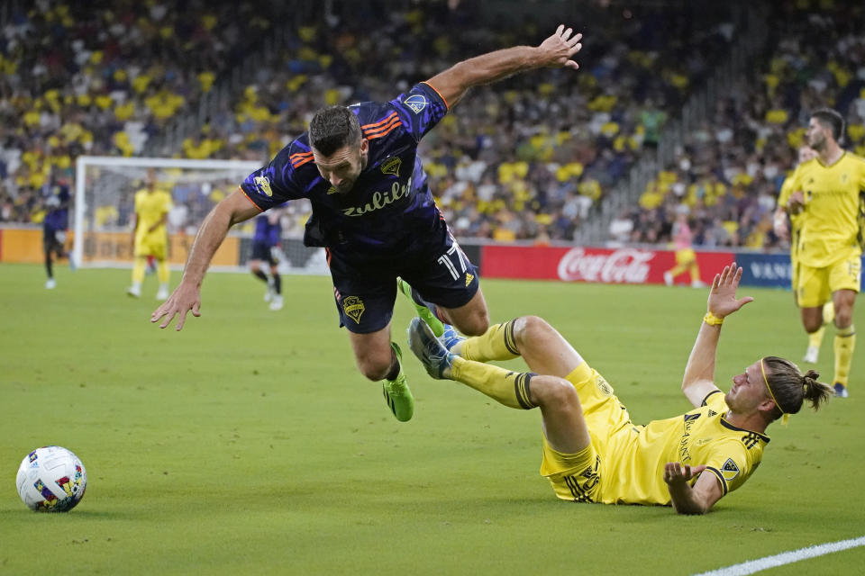 Seattle Sounders' Will Bruin (17) falls over Nashville SC's Walker Zimmerman during the second half of an MLS soccer match Wednesday, July 13, 2022, in Nashville, Tenn. (AP Photo/Mark Humphrey)