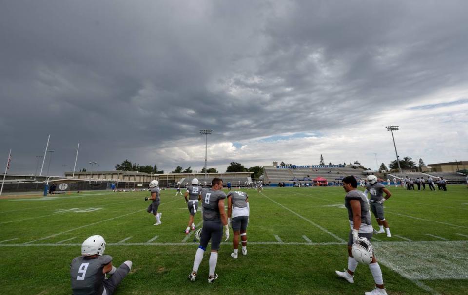 Modesto players return to the field and warm up after the team’s home opener was stopped for 45 minutes in the second quarter due to lightning strikes near Modesto Junior College in Modesto, Calif., Saturday, September 9, 2023. Modesto went on to win the game 51-41 over Santa Rosa.