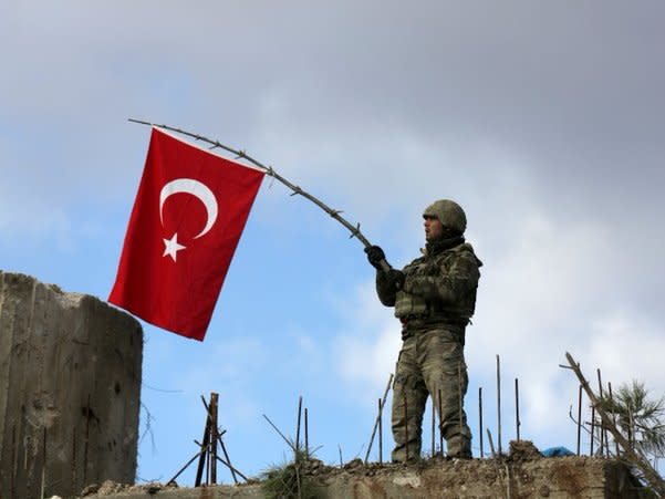 A Turkish soldier waves a flag on Mount Barsaya, northeast of Afrin, Syria January 28 ,2018. REUTERS/ Khalil Ashawi