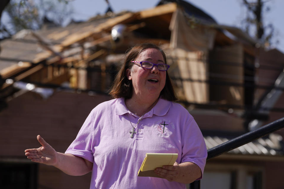 Rev. Mary Stewart, of Rolling Fork United Methodist Church, leads a prayer as people worship on the steps of the church, Sunday, March 26, 2023, in Rolling Fork, Miss. Emergency officials in Mississippi say several people have been killed by tornadoes that tore through the state on Friday night, destroying buildings and knocking out power as severe weather produced hail the size of golf balls moved through several southern states. (AP Photo/Julio Cortez)