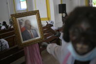 People call for justice as they point to a portrait of the late President Jovenel Moïse during a memorial service for him in the Cathedral of Cap-Haitien, Haiti, Thursday, July 22, 2021. Moïse was killed in his home on July 7. (AP Photo/Matias Delacroix)
