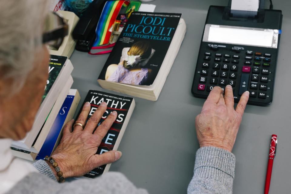 A woman rings up a customer at a bookstore.