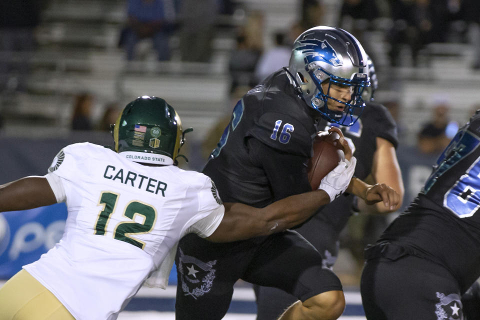 Colorado State linebacker Cam'Ron Carter (12) grabs Nevada quarterback Nate Cox (16) during the first half of an NCAA college football game in Reno, Nev., Friday, Oct. 7, 2022. (AP Photo/Tom R. Smedes)