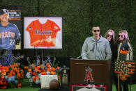 Family members of coach John Altobelli, his son J.J. Altobelli from left, with his fiancee Carly Konigsfeld and his daughter Lexi Altobelli, speaks at a memorial service honoring their father John Altobelli, his wife Keri and their daughter Alyssa who were killed in a helicopter crash on Jan. 26, at Angel Stadium of Anaheim on Monday, Feb. 10, 2020, in Anaheim, Calif. (AP Photo/Damian Dovarganes)