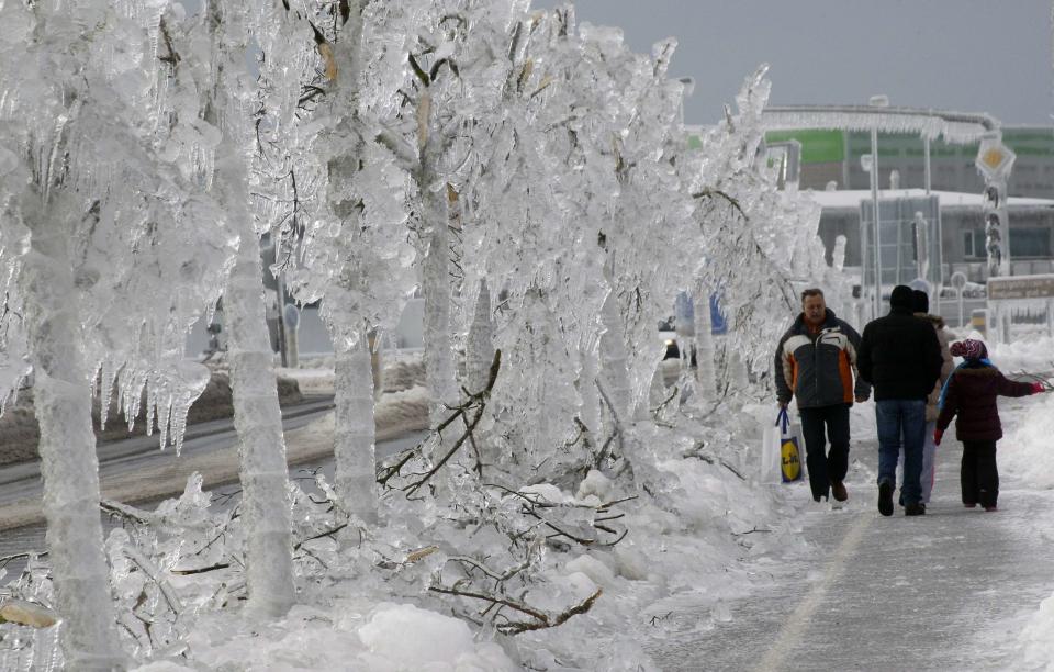 La gente camina junto a los árboles cubiertos de hielo en Postojna. REUTERS/Srdjan Zivulovic