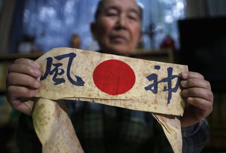 Japanese Katsumoto Saotome, 82, a survivor of Great Tokyo Air Raids in 1945, shows a headband with words reading 'Kamikaze' on it, which he carried during an evacuation in the bombing during an interview with Reuters at his home in Tokyo March 4, 2015. REUTERS/Issei Kato