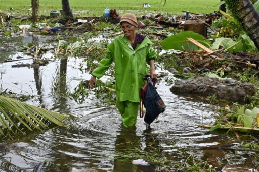 Survivors waded through knee-deep water searching for belongings outside destroyed homes