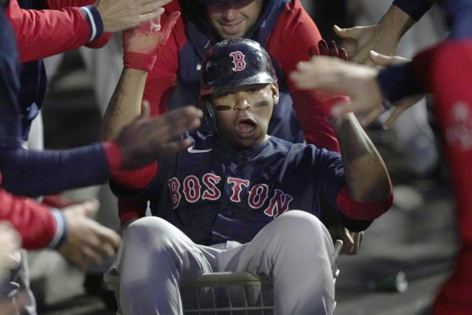 Boston Red Sox's Rafael Devers celebrates his home run in the dugout during the fourth inning of a baseball game against the Chicago White Sox Tuesday, May 24, 2022, in Chicago. (AP Photo/Charles Rex Arbogast)