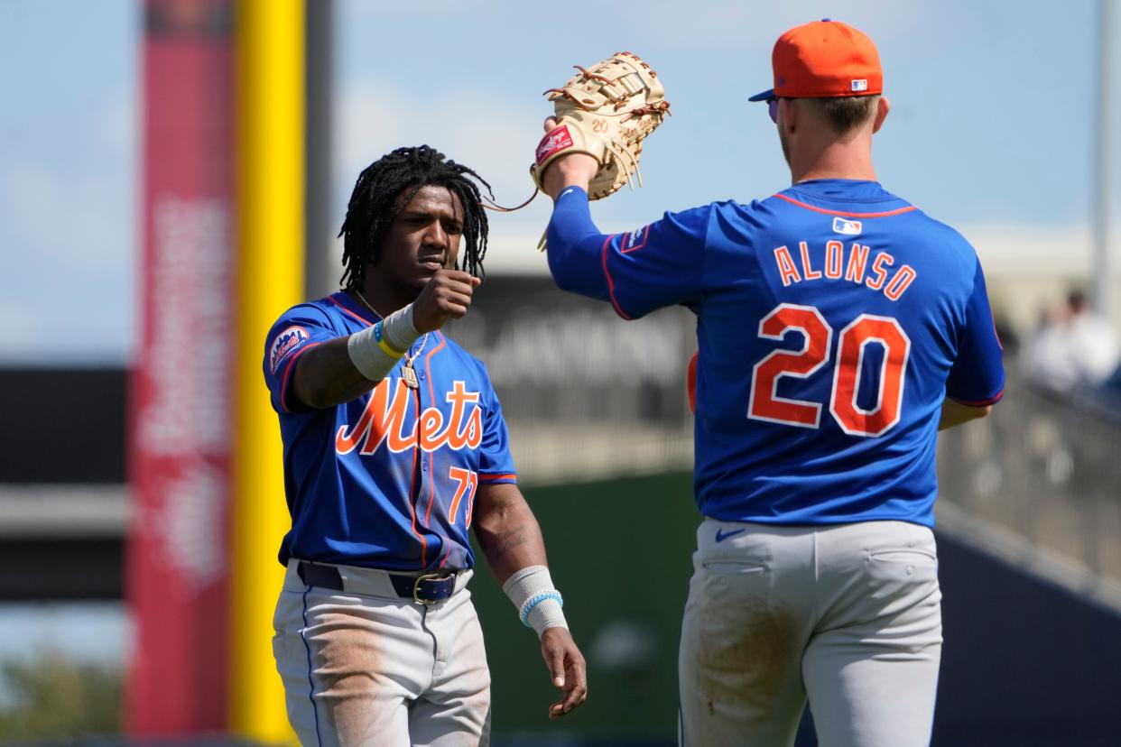 New York Mets' Luisangel Acuna, left, gets a fist bump from teammate Pete Alonso (20) as they take the field for the second inning of a spring training baseball game against the Washington Nationals Monday, Feb. 26, 2024, in West Palm Beach, Fla.