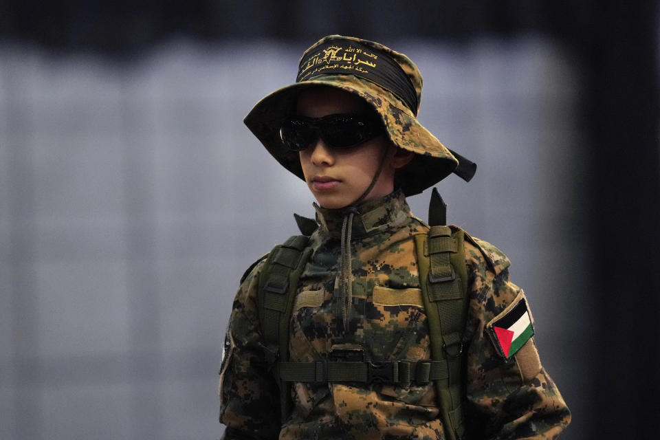 A young supporter of Hezbollah, wears their military uniform attends a rally to mark Jerusalem day, in a southern suburb of Beirut, Lebanon, Friday, April 14, 2023. Since Iran's Islamic Revolution in 1979, the rallies marking what is also known as al-Quds Day have typically been held on the last Friday of the Muslim holy month of Ramadan. (AP Photo/Hussein Malla)