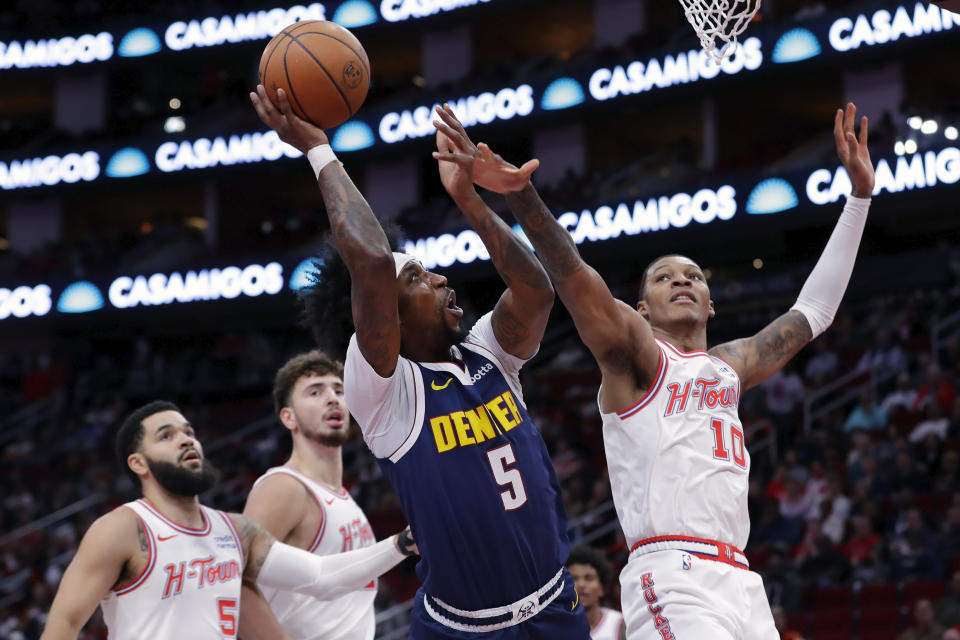 Denver Nuggets guard Kentavious Caldwell-Pope (5) puts up a shot in front of Houston Rockets players, from left, Fred VanVleet, Alperen Sengun and Jabari Smith Jr. during the first half of an NBA basketball In-Season Tournament game Friday, Nov. 24, 2023, in Houston. (AP Photo/Michael Wyke)