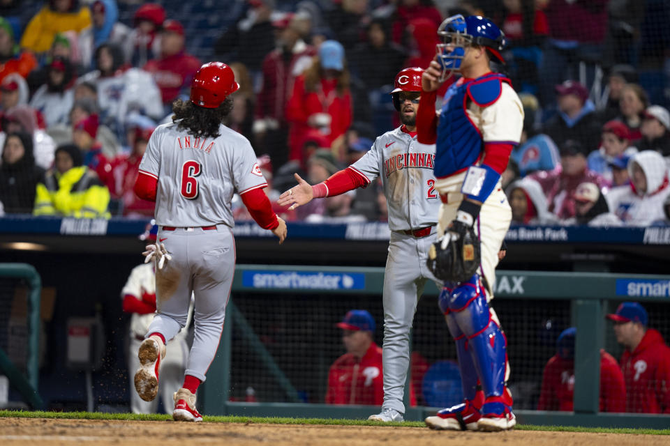 Cincinnati Reds' Nick Martini, center, celebrates with Jonathan India, left, after they scored on a double by Christian Encarnacion-Strand against the Philadelphia Phillies during the third inning of a baseball game, Wednesday, April 3, 2024, in Philadelphia. (AP Photo/Chris Szagola)