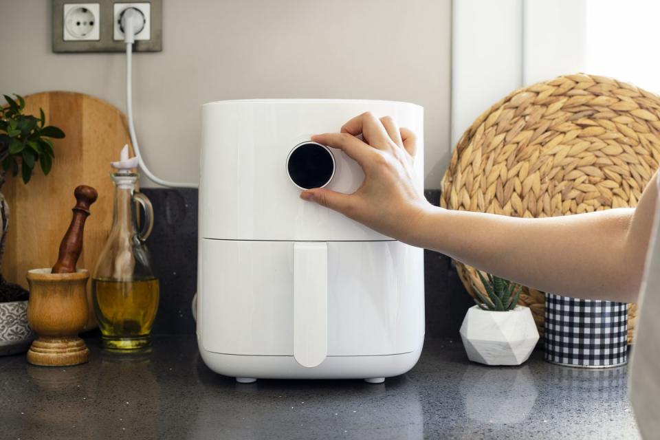 someone adjusting the settings on an air fryer